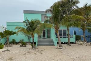 a blue house with palm trees in front of it at Villa 18 at Maralaguna in San Pedro