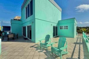a patio with green chairs and a building at Villa 18 at Maralaguna in San Pedro