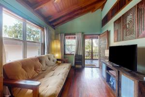 a living room with a couch and a flat screen tv at Bungalow Bobo in Placencia