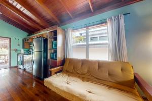 a living room with a couch and a refrigerator at Bungalow Bobo in Placencia