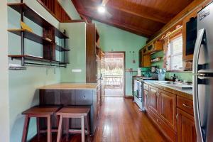 a large kitchen with wooden floors and green walls at Bungalow Bobo in Placencia