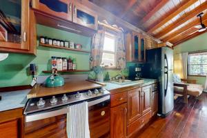 a kitchen with a stove and a refrigerator at Bungalow Bobo in Placencia