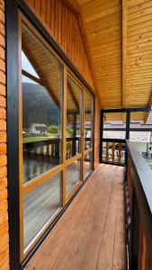a wooden deck with glass windows on a house at Demyaniv House in Tatariv