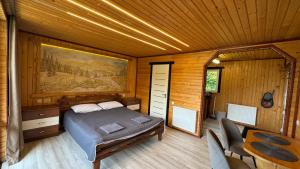 a bedroom with a bed in a wooden room at Demyaniv House in Tatariv