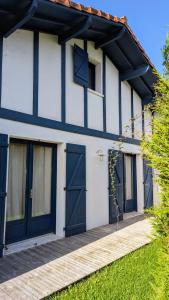 a white and blue house with blue doors at Chambre confortable Piscine Maison EtxeCosy in Bidart