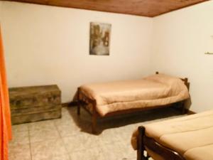 a bedroom with two beds and a ottoman in it at La casita in Pringles