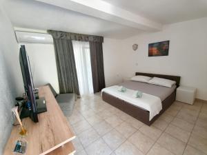 a bedroom with a bed and a flat screen tv at Apartments Šešo C in Pag +4 photos