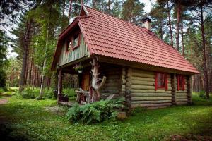 a small log cabin with a red roof at Järve Cottages in Tehumardi