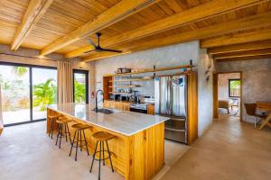 a kitchen with a large island with bar stools at Seabird - Villa 10 in Placencia