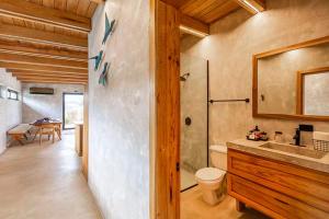 a bathroom with a shower and a toilet and a sink at Seabird - Villa 10 in Placencia