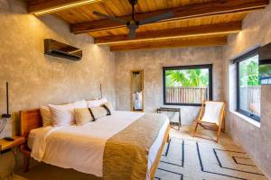 a bedroom with a large bed and a window at Seabird - Villa 10 in Placencia +10 photos