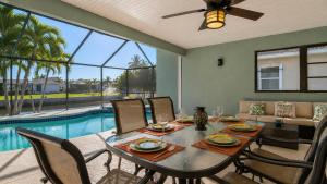 a dining room with a table and chairs and a pool at 830 Coronado in Punta Gorda