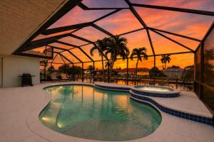 a swimming pool in a building with a sunset in the background at 830 Coronado in Punta Gorda