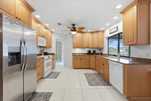 a kitchen with wooden cabinets and a stainless steel refrigerator at 830 Coronado in Punta Gorda