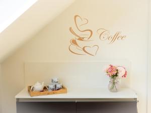 a shelf with a vase of flowers and a coffee sign at Hoeve Tramzicht in Hellevoetsluis
