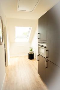 a kitchen with a refrigerator and a window at Hoeve Tramzicht in Hellevoetsluis