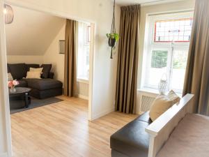 a living room with a couch and a window at Hoeve Tramzicht in Hellevoetsluis +3 photos