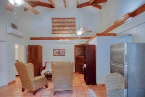 a kitchen with chairs and a refrigerator in a room at Condo #27 @ Beachside Villas in Seine Bight Village