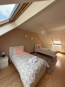 a attic bedroom with two beds and a window at Glebe cottage in Kinvara