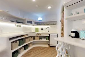 a kitchen with white counters and white shelves at Dolphin @ Swan Villas in Maya Beach