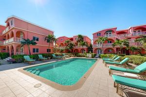 a swimming pool in front of a pink building at Palm @ Caribe Island in San Pedro