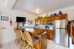 a kitchen with a bar with a stainless steel refrigerator at Palm @ Caribe Island in San Pedro +42 photos