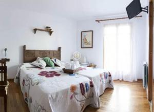 a bedroom with a bed with a floral bedspread at Casa Peiró in Coll