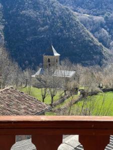 a church in a field with a mountain in the background at Casa Peiró in Coll