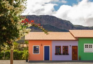 a colorful house with a mountain in the background at Vila Caetité - Mucugê in Mucugê