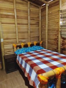 a bedroom with a bed in a room with wooden walls at Hospedaje Los Tumbilos in Silos