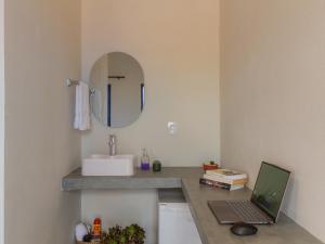a bathroom with a sink and a laptop on a counter at Vila Caetité - Mucugê in Mucugê