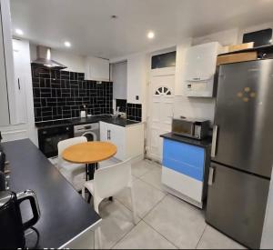 a kitchen with white appliances and a wooden table at Nowell walk in Leeds