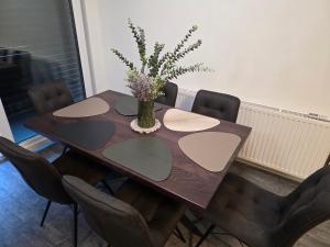 a dining room table with a vase of flowers on it at Apartman Rena in Ivanec +6 photos