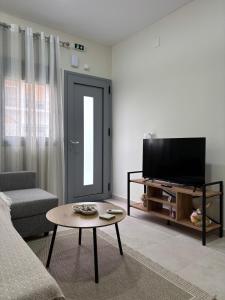 a living room with a television and a coffee table at Paloma Apartment in Drama