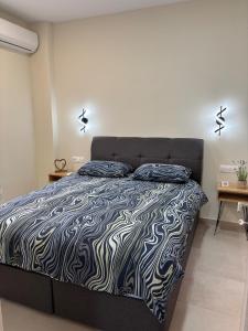 a bedroom with a bed with a black and white comforter at Paloma Apartment in Drama