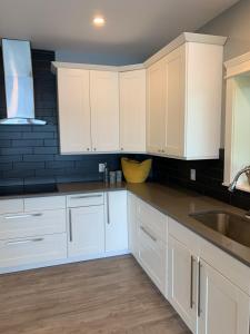 a kitchen with white cabinets and a sink at On Da Water in Lunenburg +9 photos