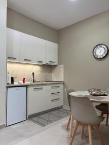a kitchen with white cabinets and a table with chairs at Paloma Apartment in Drama +12 photos