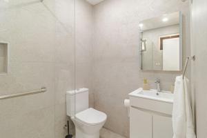 a white bathroom with a toilet and a sink at The Quinta & Studios in Quinta do Conde +54 photos