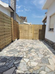 a backyard with a wooden fence and a stone patio at The Quinta & Studios in Quinta do Conde