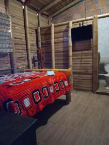 a bedroom with a bed with a red blanket at Hospedaje Los Tumbilos in Silos