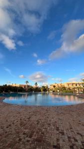 a large body of water with buildings in the background at Les Jardins de la Palmeraie 3 in Marrakesh