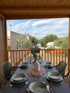a table with plates and wine glasses on a deck at Camping Matija in Betina