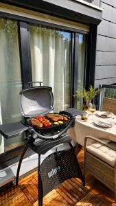 a grill with food on it on a patio at Velmora Boutique Suites - Wellness - Pool, Sauna, E-Bikes direkt am Strand in Timmendorfer Strand +7 photos