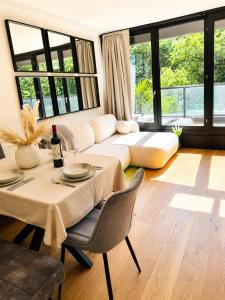 a living room with a table and a couch at Velmora Boutique Suites - Wellness - Pool, Sauna, E-Bikes direkt am Strand in Timmendorfer Strand