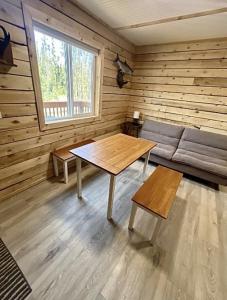 a living room with a table and a couch at Sockeye Salmon Sanctuary, Cabin 6 at Lower Kenai Lodge in Kenai