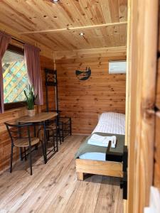 a room with a bed and a table in a cabin at Sigła w sidłach in Aleksandrów
