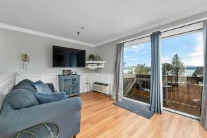a living room with a couch and a large window at Gilford Beachfront Stay, Pool, WiFi & Parking Incl in Laconia