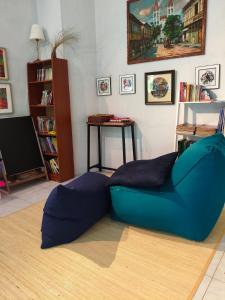 a living room with a blue couch and a tv at Pondok Ganda in Ambarita