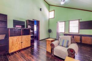 a living room with a chair and a entertainment center at Casa Jessita in Caye Caulker