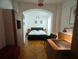 a bedroom with a bed and a table and a chair at Ralf Residence in Bucharest